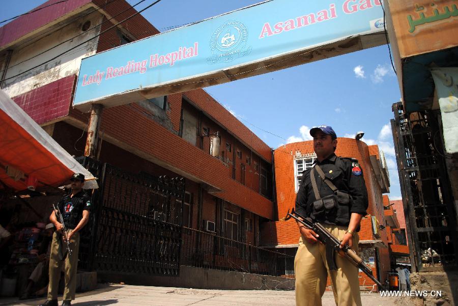 Pakistani policemen stand guard outside Lady Reading Hospital (LRH) in northwest Pakistan's Peshawar, on June 16, 2013. At least 20 people were killed and 27 others injured in a twin bomb attack followed by firing in Pakistan's southwest city of Quetta on Saturday, said police. (Xinhua/Umar Qayyum)