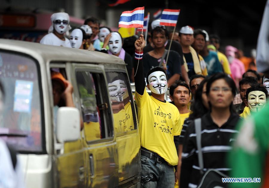 Protesters wearing masks shout slogans and hold up national flags as they stage an anti-government rally in a shopping district in Bangkok, capital of Thailand, on June 16, 2013. Thousands of protesters wearing masks held placards and shouted slogans against the government led by of Prime Minister Yingluck Shinawatra and her brother, former prime minister Thaksin Shinawatra. (Xinhua/Gao Jianjun) 