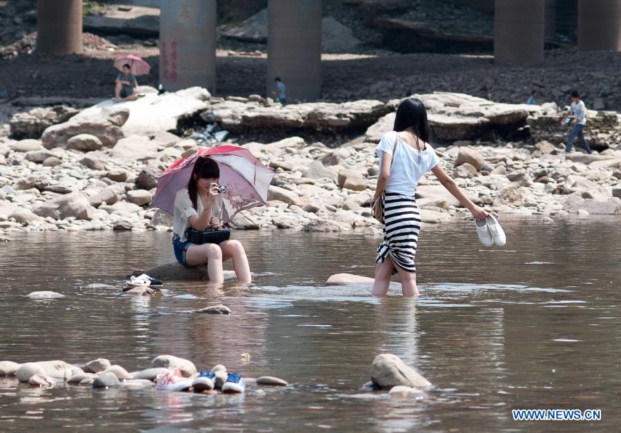 Young women cool themselves off in the Jialingjiang River at Ciqikou Town in Chongqing, southwest China's municipality, June 16, 2013. Local meteorological authorities issued an orange-coded alert of heat on Sunday, which indicates the temperature will rise up to 37 degrees Celsius Sunday afternoon. (Xinhua/Liu Chan)