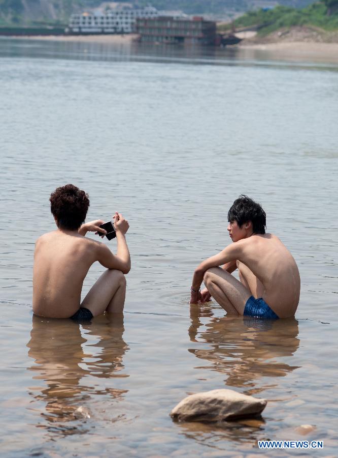 Young men cool themselves off in the Jialingjiang River at Ciqikou Town in Chongqing, southwest China's municipality, June 16, 2013. Local meteorological authorities issued an orange-coded alert of heat on Sunday, which indicates the temperature will rise up to 37 degrees Celsius Sunday afternoon. (Xinhua/Liu Chan)