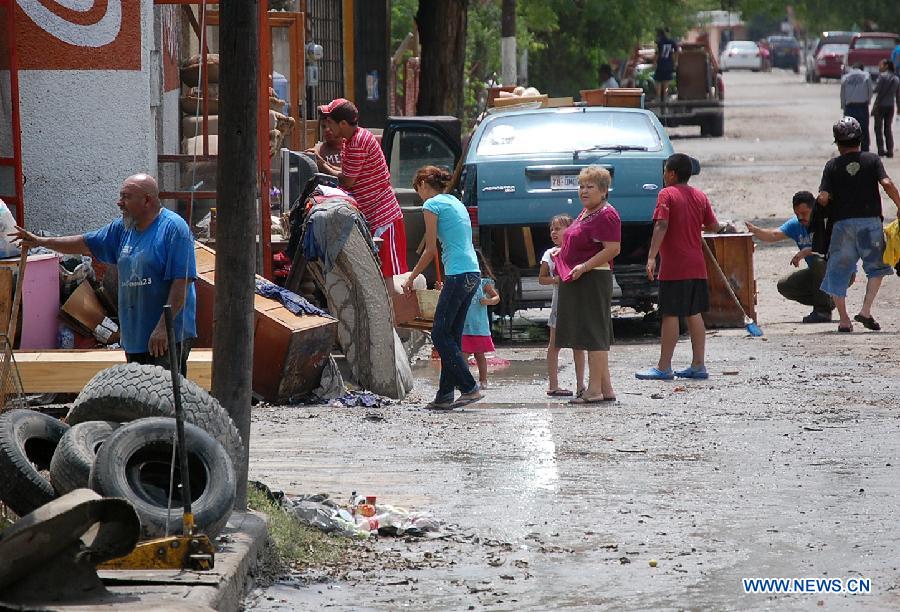 Image provided by Zocalo de Piedras Negras Newspaper shows residents trying to recover their belongings after the floods in Piedras Negras, Coahuila, Mexico, on June 16, 2013. After the heavy rains that afected Piedras Negras on Friday and Saturday, the Interior Ministry activated the DN-III Plan, and evacuated around one thousand people, according to the local media. (Xinhua/Tomas Escareno/Zocalo de Piedras Negras)
