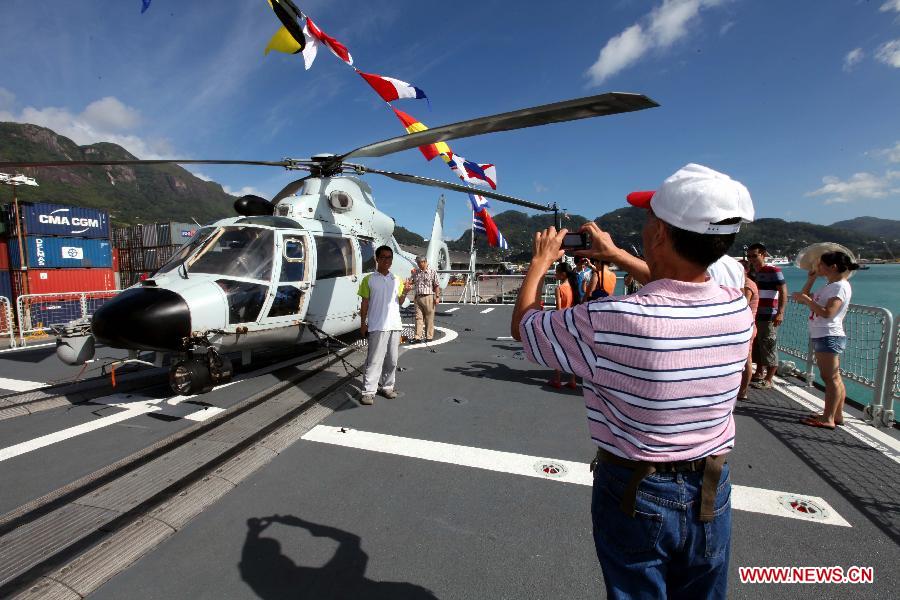 People take photos of the missile destroyer "Harbin" of the 14th Escort Taskforce of the Chinese Navy on Victoria Harbour, Seychelles, June 16, 2013. (Xinhua/Rao Rao)