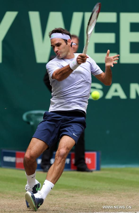 Roger Federer of Switzerland returns a shot against Mikhail Youzhny of Russia during their men's singles final match of the ATP Halle Open tennis tournament in Halle, Germany, on June 16, 2013. Federer won 2-1 to claim the title. (Xinhua/Luo Huanhuan)