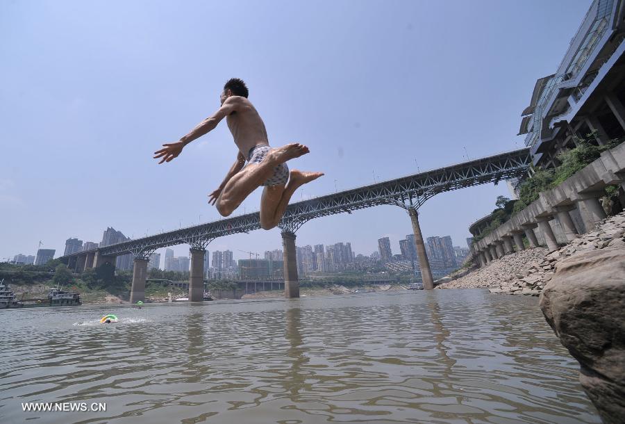 A man jumps into the Jialing River in southwest China's Chongqing Municipality, June 17, 2013. The highest temperature in Chongqing reached 39 degrees centigrade here on Monday. (Xinhua/Chen Cheng)