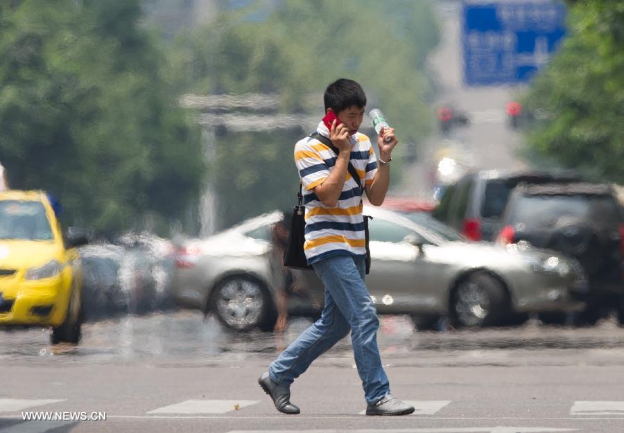 A man walks on a street in southwest China's Chongqing Municipality, June 17, 2013. The highest temperature in Chongqing reached 39 degrees centigrade here on Monday. (Xinhua/Chen Cheng) 