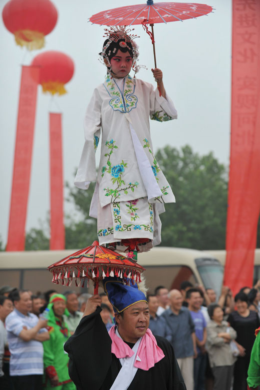 Performers stage “Quyang Qingge”, a ritual in ancient China held for praying for rain or worshiping the god, in a folk culture festival in Baoding, north China’s Hebei province, June 8, 2013. (Xinhua/Zhu Xudong)