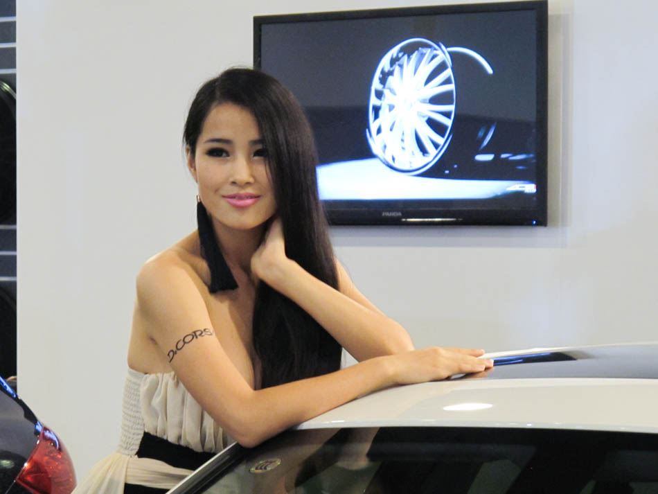 A model poses next to a modified BMW 3 displayed at the 'All in Tuning All in Caravanning' Show China 2013 on June 15, 2013, at the China National Convention Center, Beijing. [Hao Yan / chinadaily.com.cn]