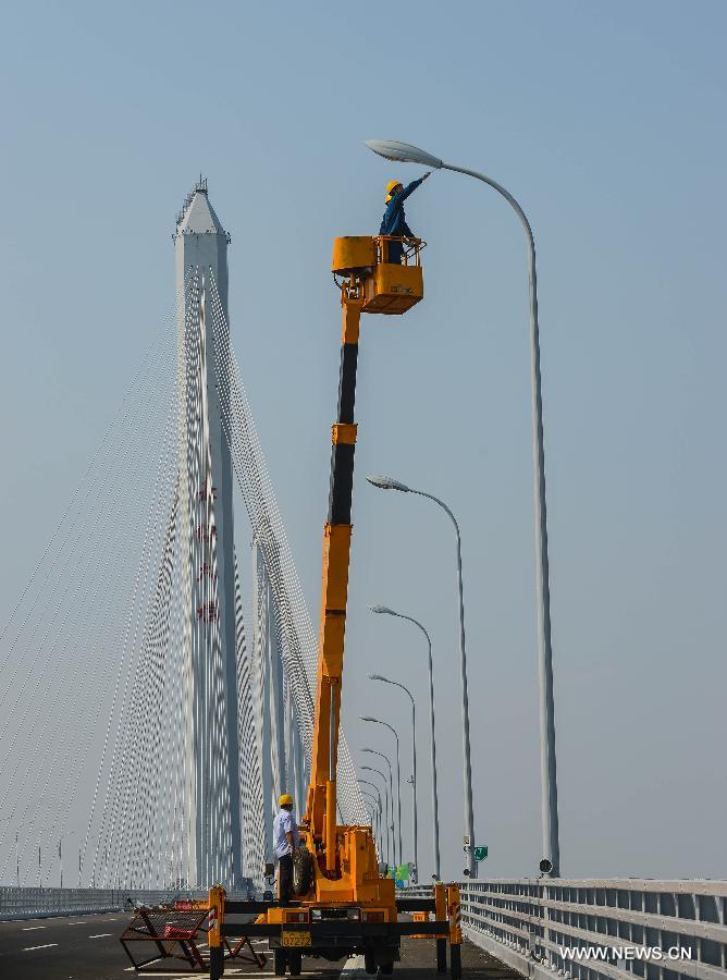 Electricians work on the Jiaxing-Shaoxing Sea Bridge in Shaoxing, east China's Zhejiang Province, June 17, 2013. The bridge was completed on June 17 and is expected to be open to traffic by the end of June. With a span of 10 kilometers over the Hangzhou Bay, it is the world's longest and widest multi-pylon cable-stayed bridge. (Xinhua/Xu Yu) 