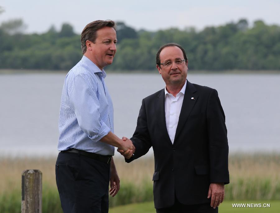 Britain's Prime Minister David Cameron (L) shakes hands with French President Francois Hollande during the official welcome as world leaders arrive for the openning ceremony of the G8 Summit at the Lough Erne resort near Enniskillen in Northern Ireland June 17, 2013. The focus of the Group of Eight (G8) industrialized nations' annual summit were expected to be on Syria and economic issues. (Xinhua/Yin Gang)