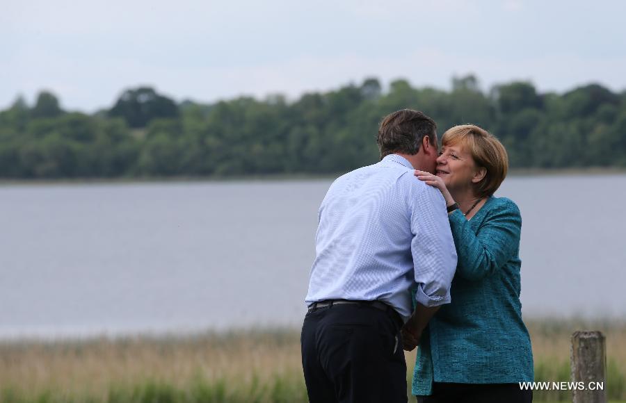 Britain's Prime Minister David Cameron (L) greets German Chancellor Angela Merkel during the official welcome as world leaders arrive for the openning ceremony of the G8 Summit at the Lough Erne resort near Enniskillen in Northern Ireland June 17, 2013. The focus of the Group of Eight (G8) industrialized nations' annual summit were expected to be on Syria and economic issues. (Xinhua/Yin Gang) 