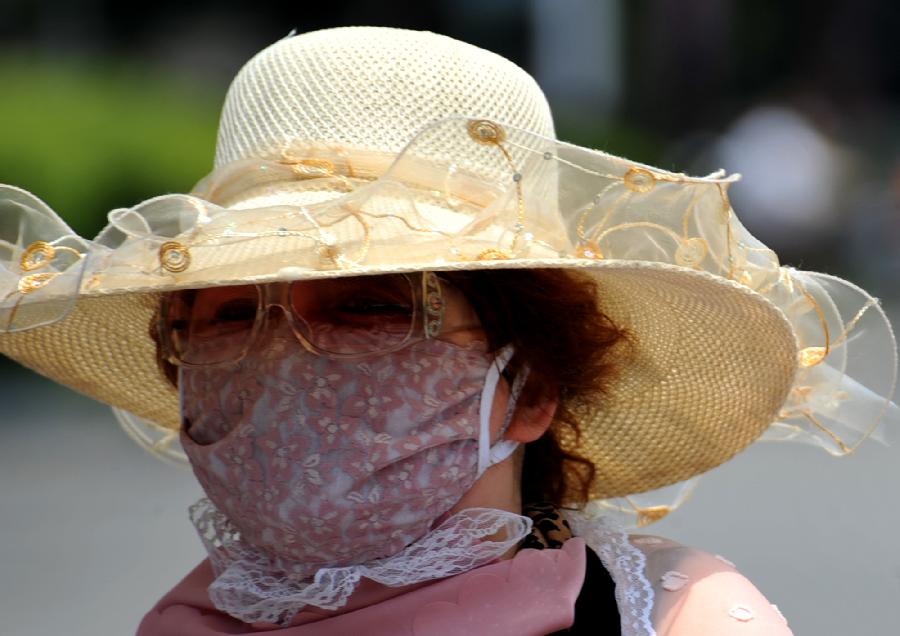 A citizen wearing mask and hat is seen in Yangzhou, east China's Jiangsu Province, June 17, 2013.The highest temperature in Yangzhou reached 36 degrees centigrade on June 17. (Xinhua/Zhuang Wenbin) 