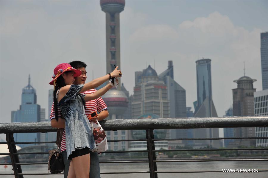 Tourists take photos at the Bund in east China's Shanghai Municipality, June 17, 2013. The highest temperature in Shanghai reached 36 degrees centigrade on Monday. (Xinhua/Liu Xiaojing) 