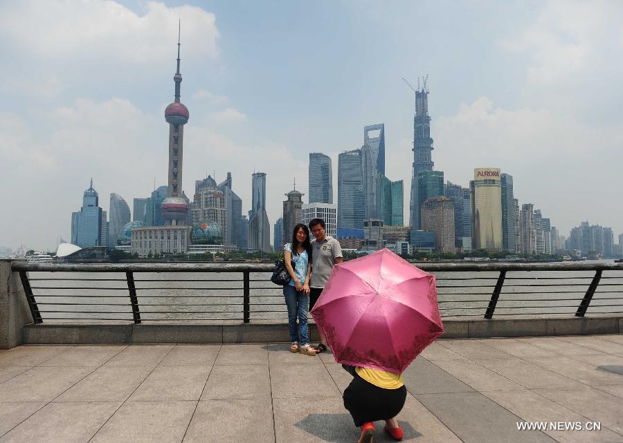 Tourists take photos at the Bund in east China's Shanghai Municipality, June 17, 2013. The highest temperature in Shanghai reached 36 degrees centigrade on Monday. (Xinhua/Liu Xiaojing) 