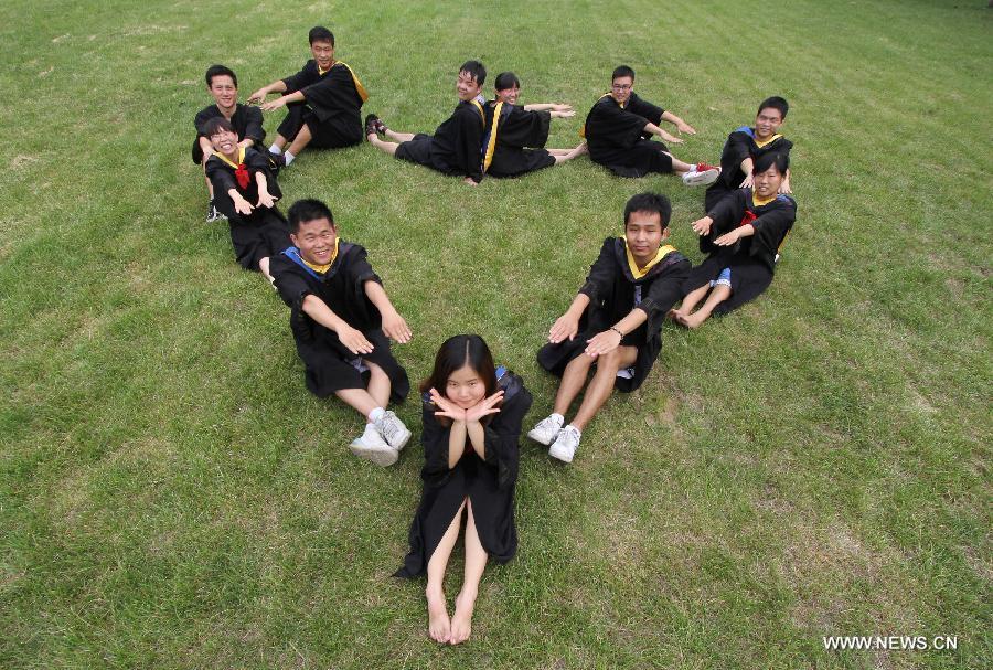 Graduates of Henan Polytechnic University pose for a group photo in Jiaozuo City, central China's Henan Province, June 17, 2013. (Xinhua/Xu Hongxing)