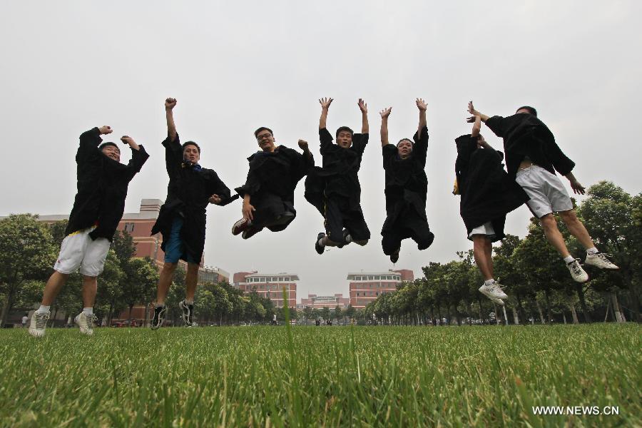 Graduates of Henan Polytechnic University pose for a group photo in Jiaozuo City, central China's Henan Province, June 17, 2013. (Xinhua/Xu Hongxing)