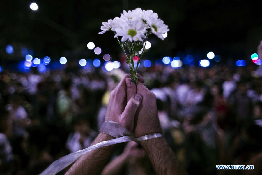 A young student holds a bunch of flowers during a protest against the millions of dollars Brazilian government spending for the FIFA Confederations Cup Brazil 2013 and World Cup Brazil 2014, at the Obelisco of Belo Horizonte, Minas Gerais state, Brazil, on June 17, 2013. The FIFA Confederations Cup Brazil 2013 is held from June 15 to June 30. (Xinhua/David de la Paz)