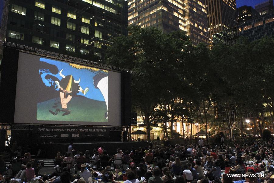 People watch a free outdoor film at Bryant Park in New York, the United States, June 17, 2013. There is a series of free outdoor films screening at Bryant Park every Monday from June 17 to August 19. (Xinhua/Cheng Li) 