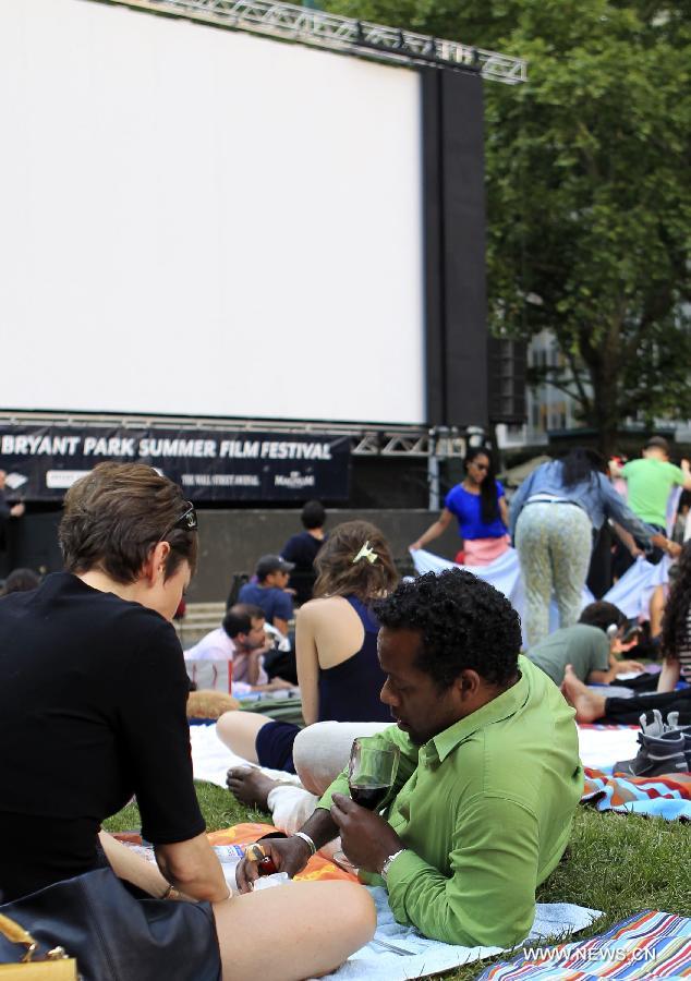 People wait for the screening of a free outdoor film at Bryant Park in New York, the United States, June 17, 2013. There is a series of free outdoor films screening at Bryant Park every Monday from June 17 to August 19. (Xinhua/Cheng Li) 