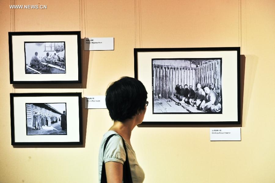 A visitor watches pictures during a photo exhibition displaying the works of Sidney D. Gamble in Beijing, capital of China, June 18, 2013. The exhibition displayed more than 100 photos taken by Gamble depicting the life of Beijing from 1908 to 1931. (Xinhua/Wang Jingsheng)