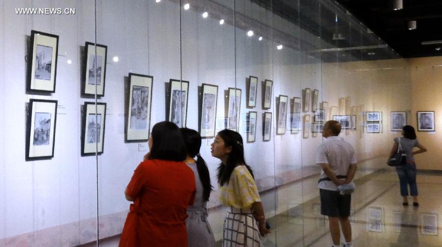 Citizens watch pictures during a photo exhibition displaying the works of Sidney D. Gamble in Beijing, capital of China, June 18, 2013. The exhibition displayed more than 100 photos taken by Gamble depicting the life of Beijing from 1908 to 1931. (Xinhua/Li Xin)