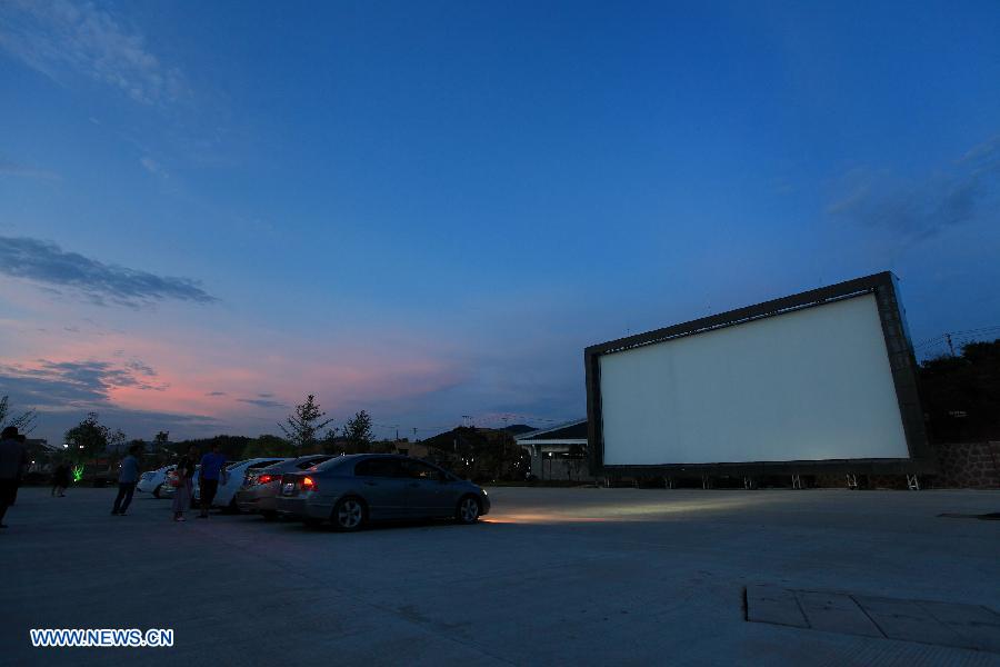 People wait in cars for the screening of films in the open-air drive-in theatre in a self-drive encampment near Wuyi Mountain, southeast China's Fujian Province, June 17, 2013. The first 3D drive-in theatre of the Fujian Province opened here recently, which occupies 5,000 square meters and can accommodate 86 cars. (Xinhua/Yi Fan)