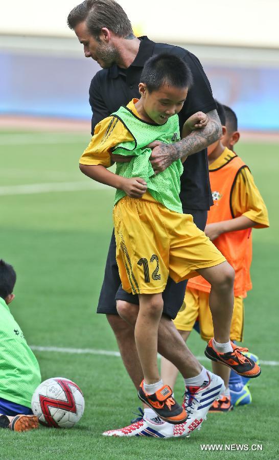 Recently retired football player David Beckham takes part in a training session with students at Nanjing Olympic Center in Nanjing, east China's Jiangsu Province, June 18, 2013. Beckham is on a seven-day visit to China as the ambassador for the Football Programme in China and China's Super League. (Xinhua/Yang Lei)