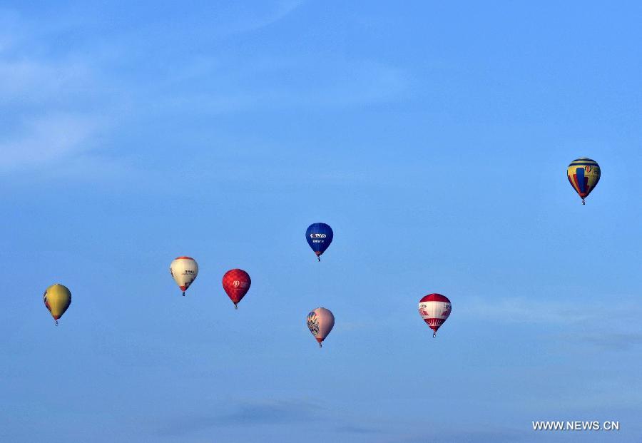 Hot air balloons are seen in the air during the 7th Hot Air Balloon Festival and 2013 H1 China Hot Air Balloon Challenge in Haikou, capital of southernmost China's Hainan Province, June 18, 2013. 15 hot air balloons participated in the event Tuesday to to fly across the Qiongzhou Strait from the city of Haikou and reach a designated place in neighboring Guangdong Province. (Xinhua/Jiang Jurong)