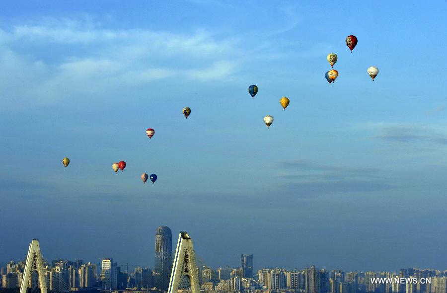 Hot air balloons fly over the city zone during the 7th Hot Air Balloon Festival and 2013 H1 China Hot Air Balloon Challenge in Haikou, capital of southernmost China's Hainan Province, June 18, 2013. 15 hot air balloons participated in the event Tuesday to to fly across the Qiongzhou Strait from the city of Haikou and reach a designated place in neighboring Guangdong Province. (Xinhua/Jiang Jurong)