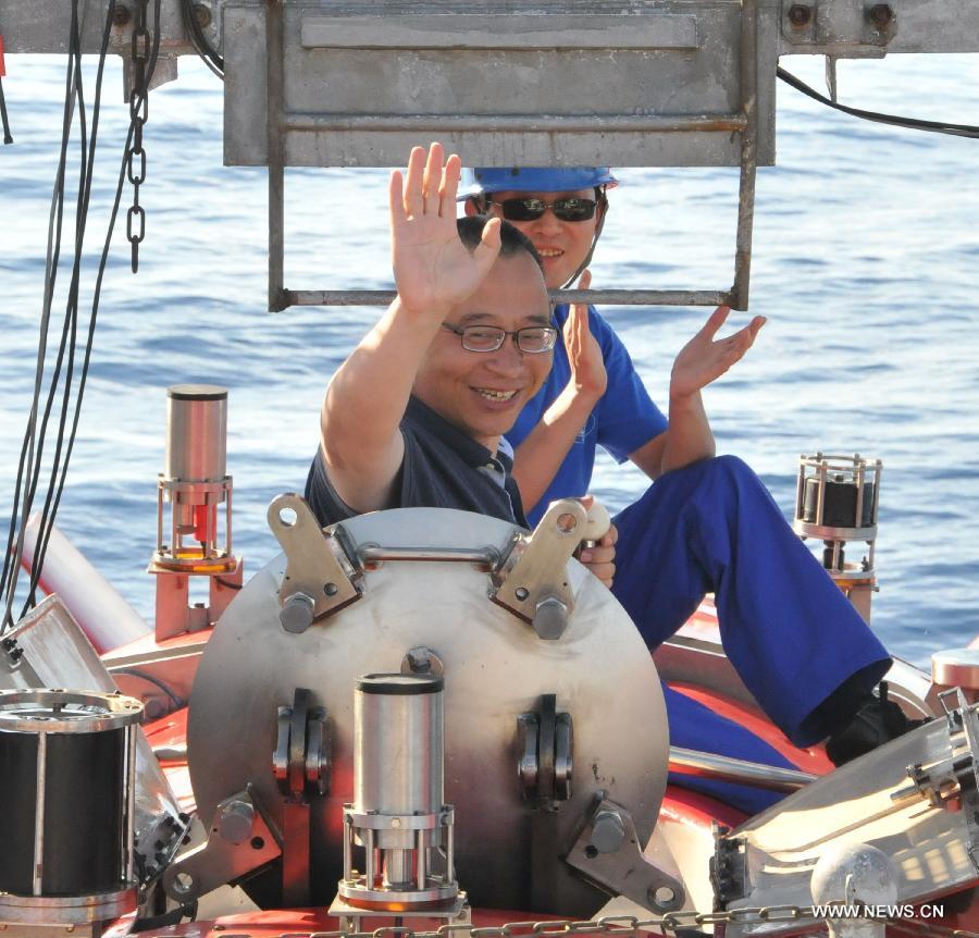 Professor Zhou Huaiyang (front) waves as he comes out of the Jiaolong manned deep-sea submersible after a deep-sea dive into the south China sea, June 18, 2013. The Jiaolong manned deep-sea submersible on Tuesday carried its first scientist Zhou Huaiyang, professor of the School of Marine and Earth Science at Tongji University, as crew member during a deep-sea dive. (Xinhua/Zhang Xudong)