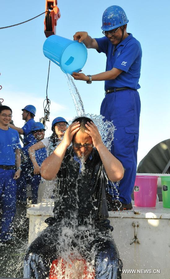 A staff member welcomes professor Zhou Huaiyang's coming back by pouring water on him after a deep-sea dive into the south China sea, June 18, 2013. The Jiaolong manned deep-sea submersible on Tuesday carried its first scientist Zhou Huaiyang, professor of the School of Marine and Earth Science at Tongji University, as crew member during a deep-sea dive. (Xinhua/Zhang Xudong)