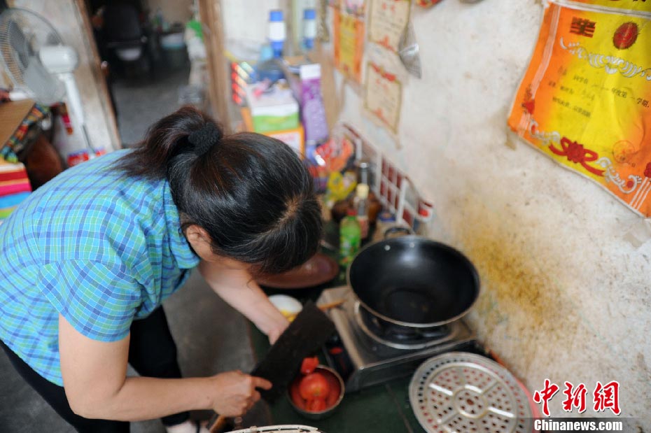 Ms. Xue prepares breakfast for the family. Although she can't afford milk and bread, she felt happy when she saw her daughter have breakfast she made. (Photo/CNS)