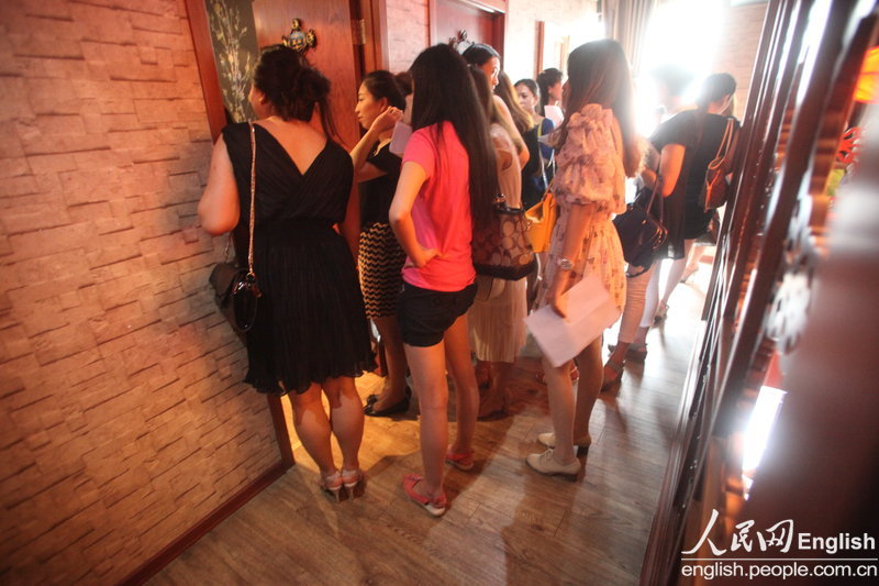 The candidates wait for their turns in the corridor during a "rich blind date" held in Jinan, capital city of east China's Shandong province, June 16, 2013. Fifty candidates taking part in the "rich blind date" will be selected to attend a party for rich individuals to be held overseas in July. (Photo by Pan Yongqiang/ CFP)