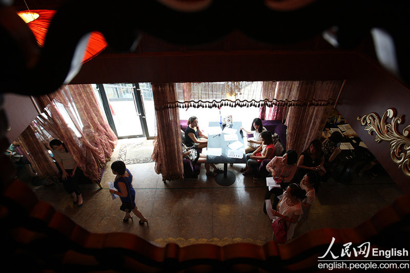 Candidates fill in forms prior to a so-called "rich blind date" held in Jinan, capital city of east China's Shandong province, June 16, 2013. Fifty candidates taking part in the "rich blind date" will be selected to attend a party for rich individuals to be held overseas in July. (Photo by Pan Yongqiang/ CFP)