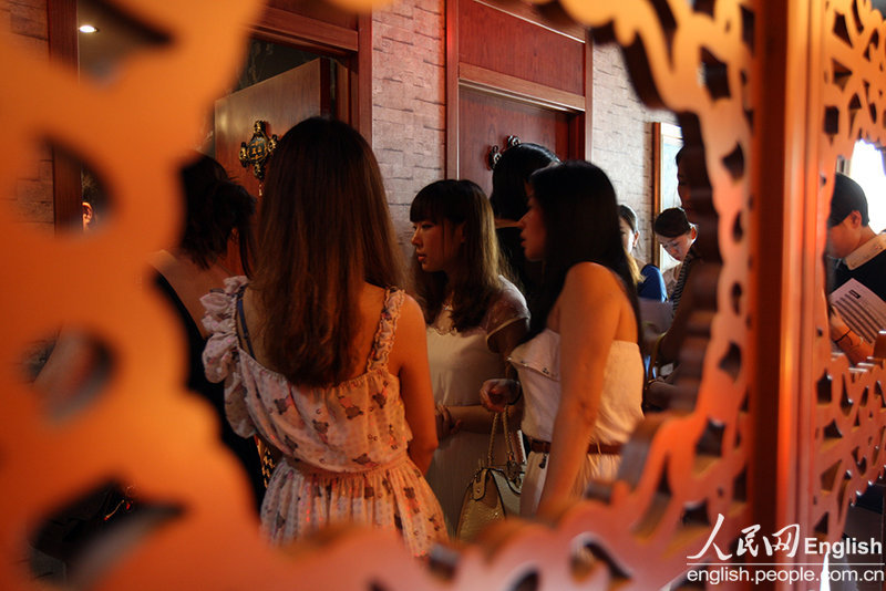 The candidates wait for their turns in the corridor during a "rich blind date" held in Jinan, capital city of east China's Shandong province, June 16, 2013. Fifty candidates taking part in the "rich blind date" will be selected to attend a party for rich individuals to be held overseas in July. (Photo by Pan Yongqiang/ CFP)