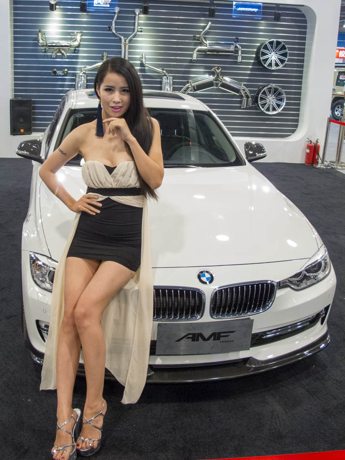 A model stands by a modified BMW 3 series car displayed at the 'All in Tuning All in Caravanning' Show China 2013 on June 15, 2013, at the China National Convention Center, Beijing. [Hao Yan / chinadaily.com.cn]