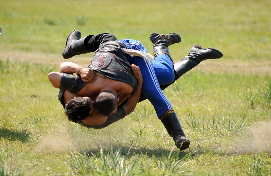 Herdsmen of the Owenke ethnic group wrestle at the annual Sebin (Happiness) Festival in Owenke Autonomous Banner, north China's Inner Mongolia Autonomous Region, June 18, 2013. The Owenke ethnic group has the reputation of the "last hunting tribe in China". (Xinhua/Liu Yongzhen) 