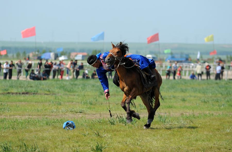 A herdsman of the Owenke ethnic group performs at the annual Sebin (Happiness) Festival in Owenke Autonomous Banner, north China's Inner Mongolia Autonomous Region, June 18, 2013. The Owenke ethnic group has the reputation of the "last hunting tribe in China". (Xinhua/Liu Yongzhen)