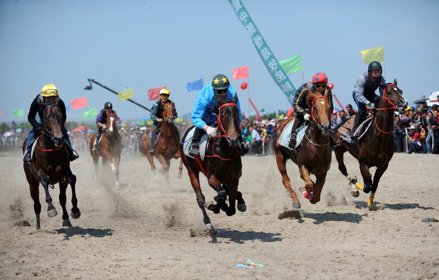 Herdsmen of the Owenke ethnic group participate in a horse race at the annual Sebin (Happiness) Festival in Owenke Autonomous Banner, north China's Inner Mongolia Autonomous Region, June 18, 2013. The Owenke ethnic group has the reputation of the "last hunting tribe in China". (Xinhua/Liu Yongzhen)