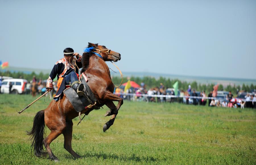 A herdsman of the Owenke ethnic group rides a horse at the annual Sebin (Happiness) Festival in Owenke Autonomous Banner, north China's Inner Mongolia Autonomous Region, June 18, 2013. The Owenke ethnic group has the reputation of the "last hunting tribe in China". (Xinhua/Liu Yongzhen)