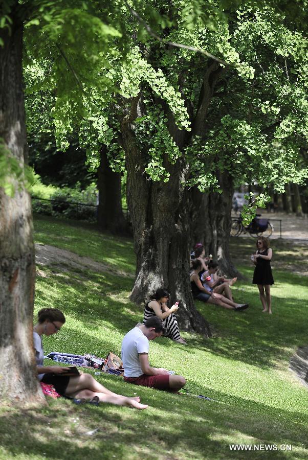 Students study in shade at a park near the library of Catholic University of Louvain in Louvain, Belgium, June 18, 2013. The local temperature on Tuesday has reached 31 degrees Celsius, the highest since this year, after an unusually wet and cold winter and spring. (Xinhua/Ye Pingfan) 