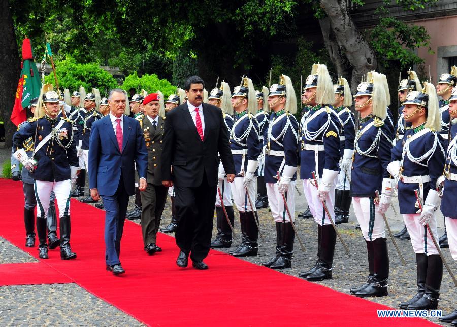 Visiting Venezuelan President Nicolas Maduro (R, front), accompanied by his Portuguese counterpart Anibal Cavaco Silva (L, front), reviews an honor guard at the presidential palace in Lisbon, Portugal, on June 18, 2013. Maduro arrived in Lisbon on Tuesday for an official visit. He held talks with President Anibal Cavaco Silva and Prime Minister Passos Coelho separately. (Xinhua/Zhang Liyun)