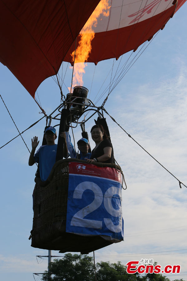 A hot air balloon takes off in Evergreen Garden in Haikou, South China's Hainan Province, June 18, 2013. An air balloon competition kicked off on Tuesday, in which contestants are requested to fly across the Qiongzhou Strait from Haikou and reach a designated place in Xunwen County in the neighboring Guangdong Province.  (CNS/Wang Xinli)