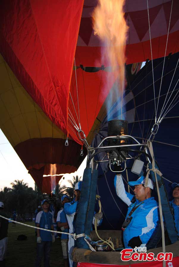 Contestants prepare for an air balloon competition in Evergreen Garden in Haikou, South China's Hainan Province, June 18, 2013. The air balloon competition kicked off on Tuesday, in which contestants are requested to fly across the Qiongzhou Strait from Haikou and reach a designated place in Xunwen County in the neighboring Guangdong Province. (CNS/Wang Xinli)