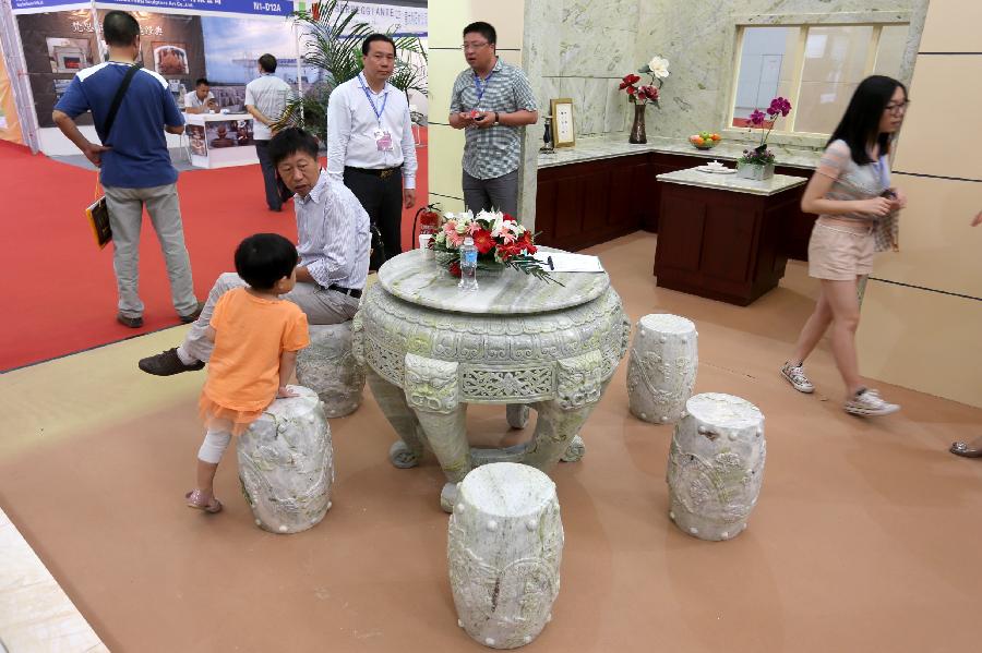 TIANJIN, June 19, 2013 (Xinhua) -- People visit the stone-carving desk and chairs during the 2nd China (Tianjin) International Stone Blocks, Products & Equipment Exposition in Tianjin, north China, June 18, 2013. The exposition, opened here on Tuesday, has attracted more than 800 related enterprises both at home and abroad.(Xinhua/Wang Qingyan)  