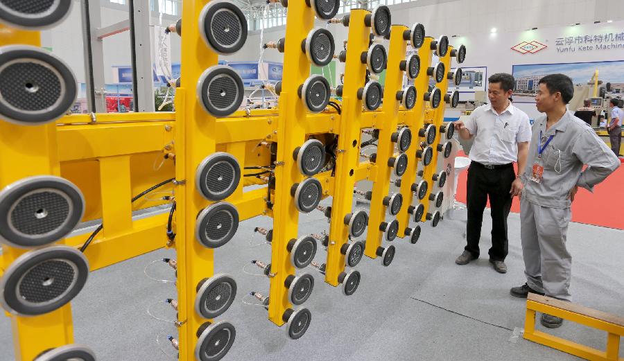 People visit the automatic manipulators during the 2nd China (Tianjin) International Stone Blocks, Products & Equipment Exposition in Tianjin, north China, June 18, 2013. The exposition, opened here on Tuesday, has attracted more than 800 related enterprises both at home and abroad.(Xinhua/Wang Qingyan)