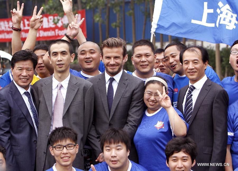Recently retired football player David Beckham takes photos with fans at Shanghai Shenxin Football club in Shanghai, east China, June 19, 2013. David Beckham is on a seven-day visit to China as the ambassador for the Football Programme in China and China's Super League. (Xinhua/Fan Jun) 