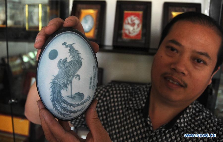 Pu Derong, a man from Dongzhuangtou Village in Zhuozhou City, shows his egg carving work in Zhuozhou, north China's Hebei Province, June 19, 2013. Pu, who started egg carving in 1995, have won several awards in various contests and exhibitions. (Xinhua/Wang Xiao) 