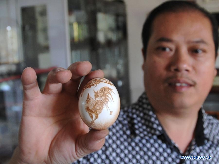 Pu Derong, a man from Dongzhuangtou Village in Zhuozhou City, shows his egg carving work in Zhuozhou, north China's Hebei Province, June 19, 2013. Pu, who started egg carving in 1995, have won several awards in various contests and exhibitions. (Xinhua/Wang Xiao)