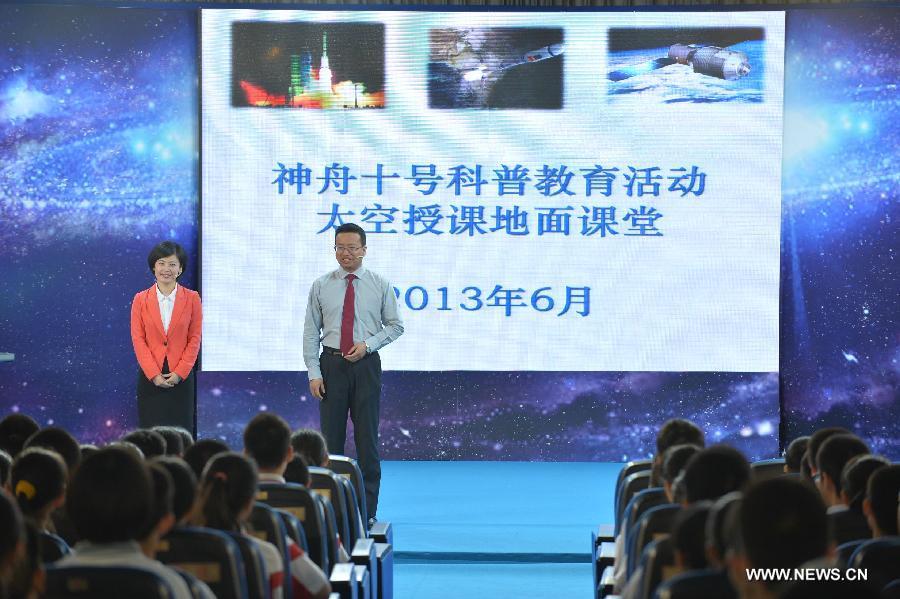 Teachers and students wait for the beginning of the space lecture at the ground classroom set at the High School Affiliated to Renmin University of China, in Beijing, capital of China, June 20, 2013. A special lecture will begin at about 10:00 a.m. Beijing time Thursday morning, given by a teacher aboard China's space module Tiangong-1 to students on Earth. (Xinhua/Li Xin)