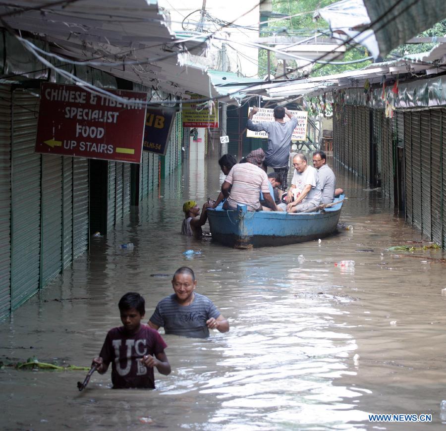 People ride boat to higher ground after floodwaters inundated homes along the banks of the Yamuna River in New Delhi, India, June 19, 2013. The Indian capital has been put on flood alert after its main Yamuna river breached the danger mark following incessant rainfall since June 16. (Xinhua/Partha Sarkar) 